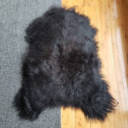 Black icelandic sheepskin rug on floor