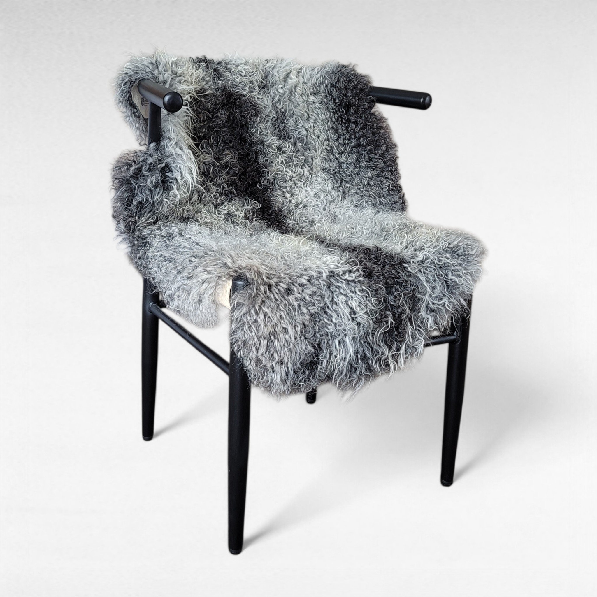 Purebred Gotland Sheepskin 39" x 23" Gray Gotland sheepskin pelt shown in a chair used as a seat cushion and throw