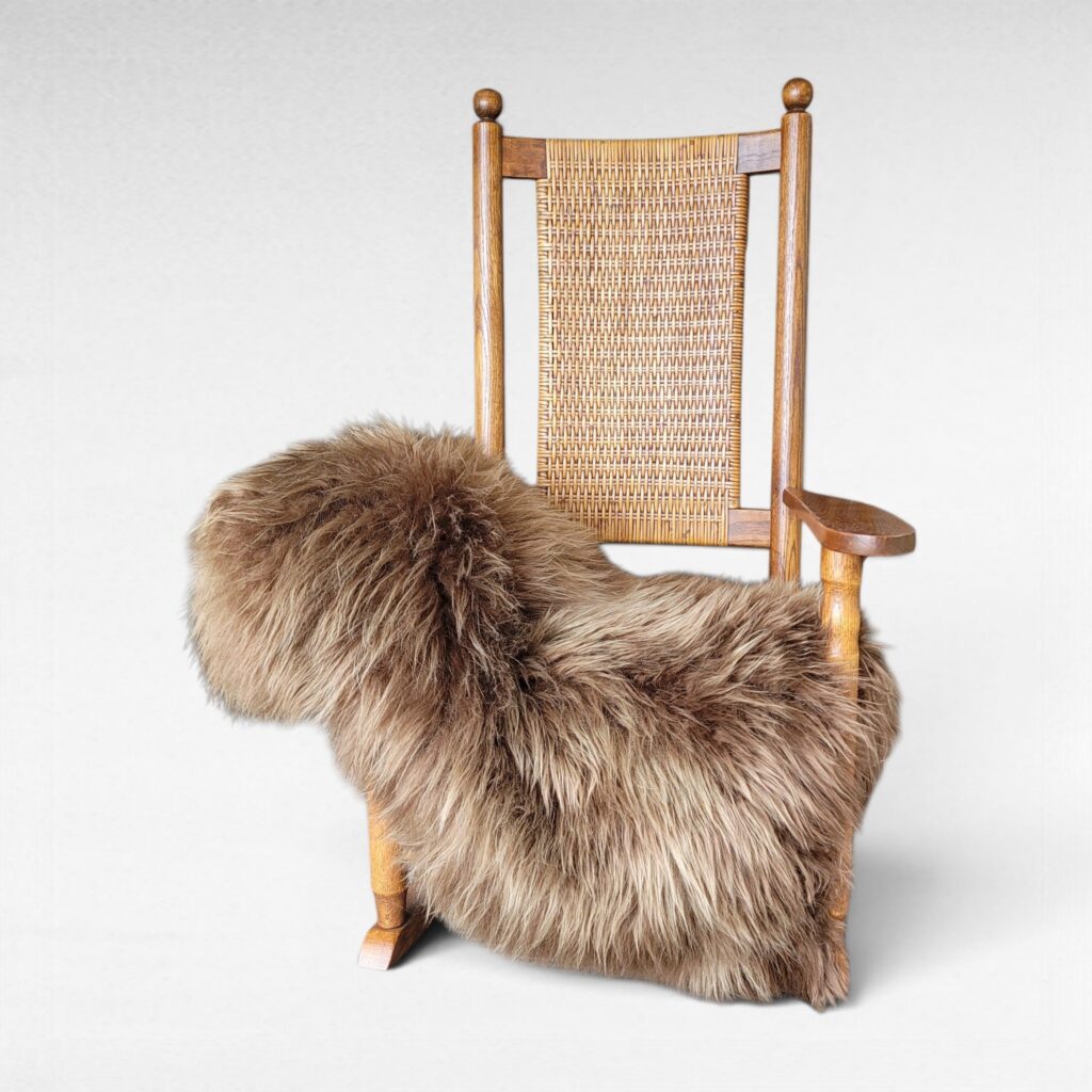 Light golden brown sheepskin rug displayed on a rocking chair as a soft textured throw