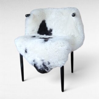 Plush sheepskin rug displayed in a chair so you can see the texture and unique markings