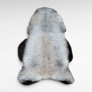 Soft gray wool sheepskin rug shown laying on a flat surface to display the natural colors and markings. This pelt is made out of genuine organic Icelandic sheepskin