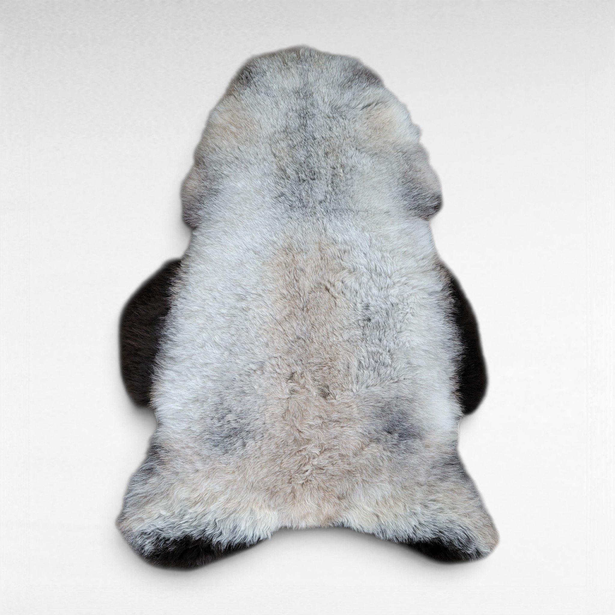 Soft gray wool sheepskin rug shown laying on a flat surface to display the natural colors and markings. This pelt is made out of genuine organic Icelandic sheepskin