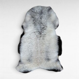 Gray sheepskin rug shown laying on a flat surface to display the natural colors and markings. This pelt is made out of genuine organic Icelandic sheepskin