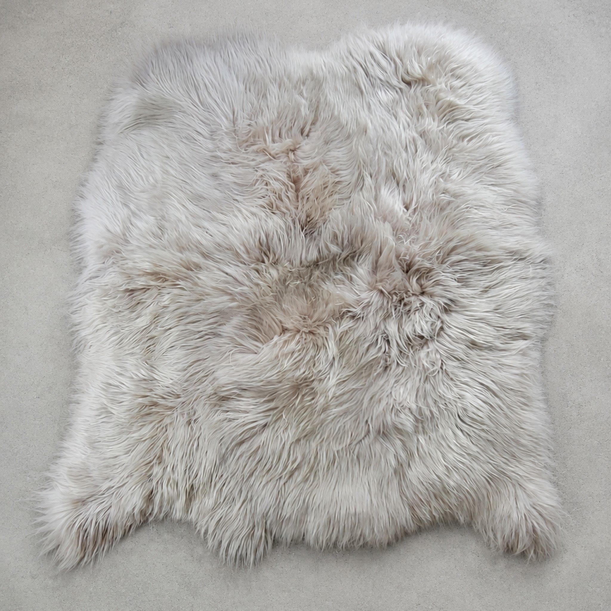 Genuine thick pile sheepskin area rug made using 100% Icelandic fur hides - eco-dyed in a stunning linen color. Left in an organic shape sheep skin shape.